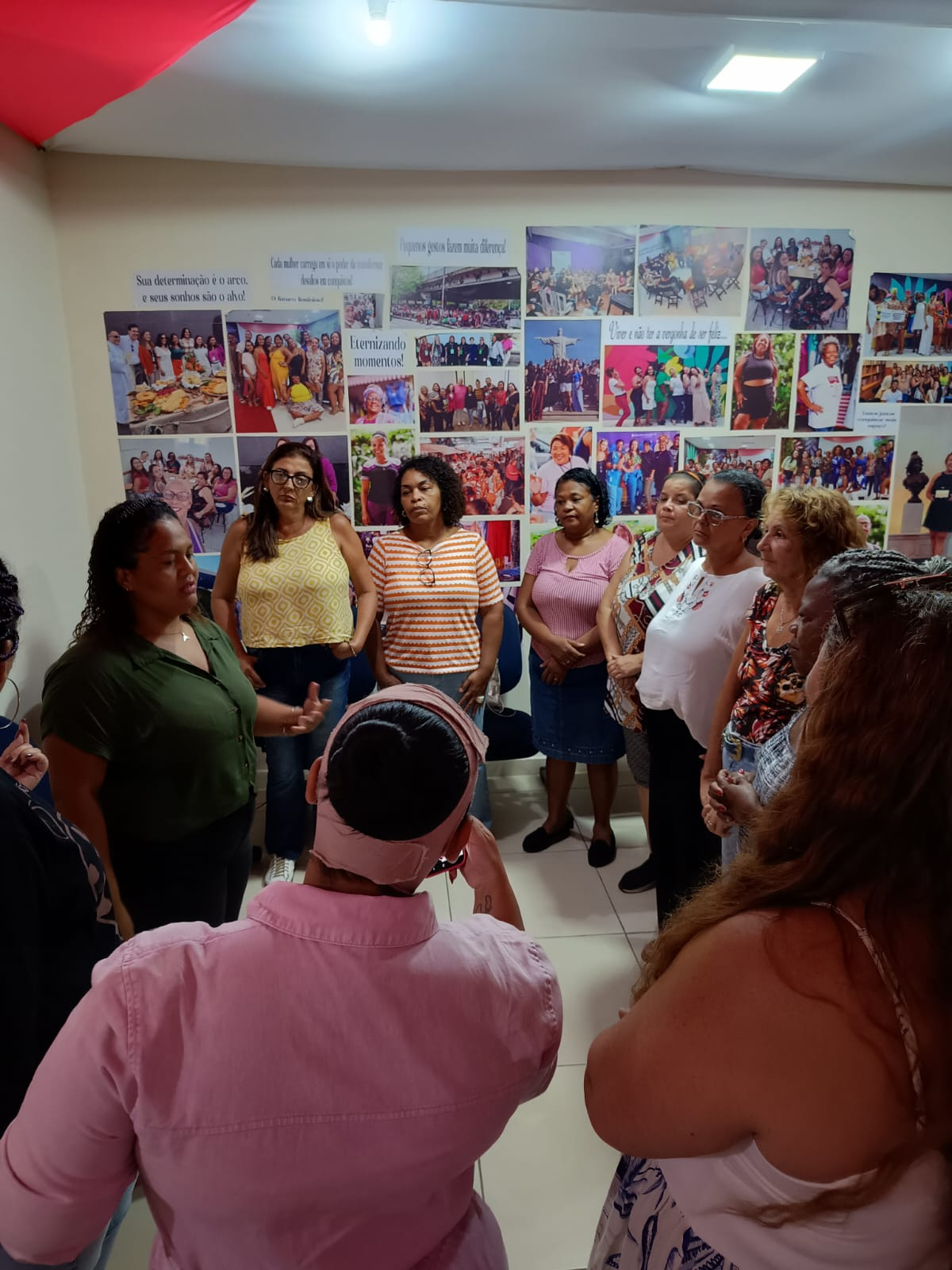 Roda de conversa com mulheres na sede do projeto, diante do mural de fotos